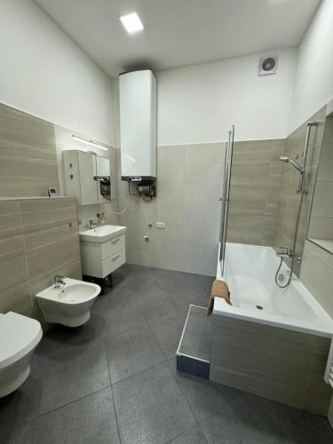 a bathroom with a tub and a toilet and a sink at V centru Znojma s vybavením pro děti a garáží pro kola in Znojmo
