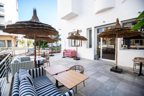 a patio with tables and chairs and umbrellas at Noreba Hospitality in Tangier