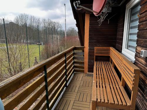 a wooden porch with a bench on the side of a house at Wohnung für Monteure & Handwerker in Neustadt am Kulm
