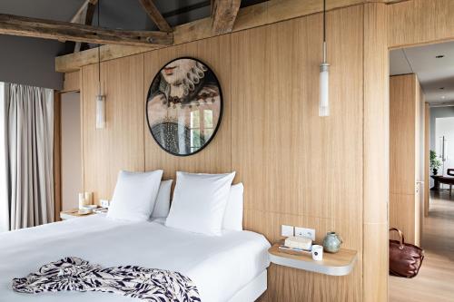 a bedroom with a bed and a picture on the wall at Domaine de la Reine Margot Paris-Issy - MGallery Collection in Issy-les-Moulineaux