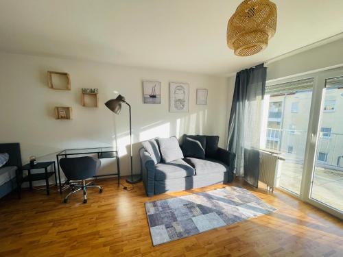 a living room with a couch and a desk at Sonnige, zentralgelegene Wohnung in Pforzheim