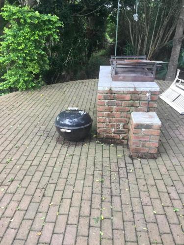 a black dog bowl sitting on a brick patio at Coelacanth Sea & River Lodge in Kayserʼs Beach