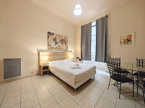 a bedroom with a bed and a table and a television at Viva Riviera Residence Marina Croisette in Cannes