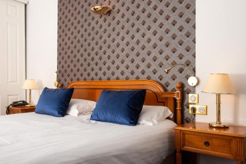 une chambre avec un lit avec deux oreillers bleus dans l'établissement Sun Riviera Hotel, à Cannes