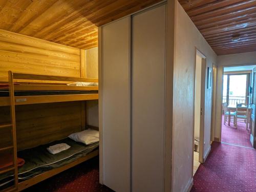 une chambre avec des lits superposés et une salle à manger dans l'établissement Studio chaleureux au pied des pistes, animaux admis - FR-1-811-9, à Les Deux Alpes