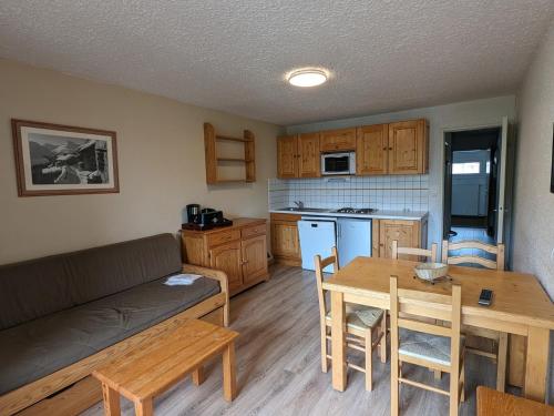 un salon et une cuisine avec un canapé et une table dans l'établissement Studio fonctionnel avec balcon, au pied des pistes, animaux admis - FR-1-811-32, à Les Deux Alpes