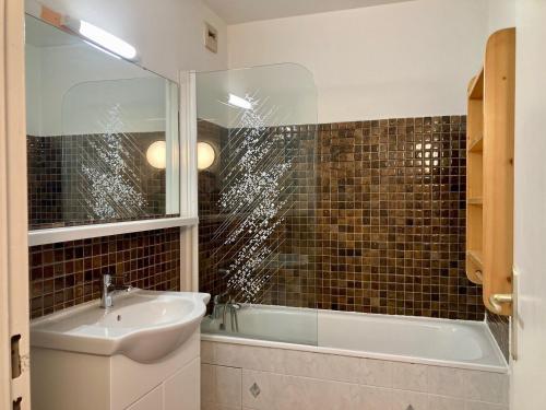 une salle de bain avec un lavabo et une baignoire dans l'établissement Studio lumineux au pied des pistes, animaux admis - FR-1-811-35, à Les Deux Alpes