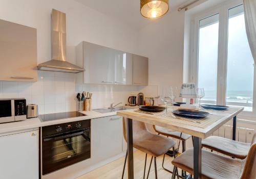 - une cuisine avec une table, des chaises et un comptoir dans l'établissement Appartement Saint-Malo - Vue mer, à Saint-Malo