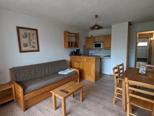 un salon avec un canapé et une table et une cuisine dans l'établissement Studio familial au pied des pistes, animaux acceptés - FR-1-811-6, à Les Deux Alpes