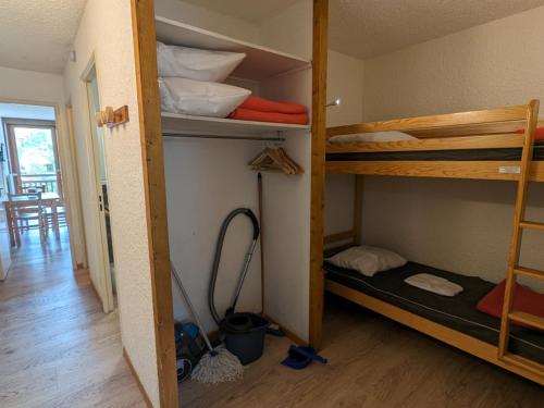 Cette chambre comprend 2 lits superposés et un couloir. dans l'établissement Studio familial au pied des pistes, animaux acceptés - FR-1-811-6, à Les Deux Alpes