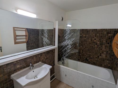 une salle de bain avec un lavabo et une baignoire dans l'établissement Studio familial au pied des pistes, animaux acceptés - FR-1-811-6, à Les Deux Alpes