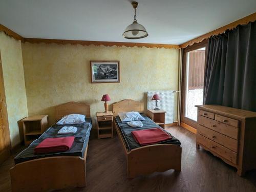 une chambre avec deux lits et une fenêtre dans l'établissement Appartement lumineux 6 pers, au pied des pistes, centre station, animaux admis - FR-1-811-34, à Les Deux Alpes