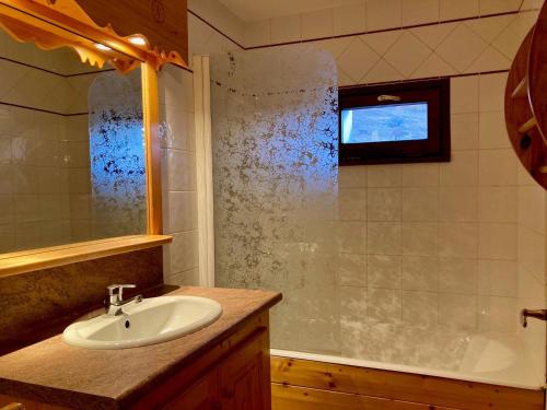 une salle de bain avec un lavabo et une baignoire dans l'établissement Duplex sous les toits, pied des pistes, animaux admis - FR-1-811-37, à Les Deux Alpes