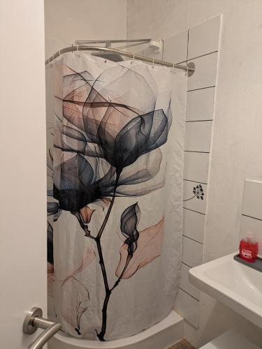 einen Duschvorhang mit Blume im Bad in der Unterkunft Kleine Sonnenstrahl-Oase in Frielendorf