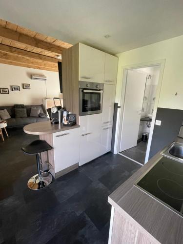 cocina con armarios blancos y taburete en CS Casa Serena, en Vairano