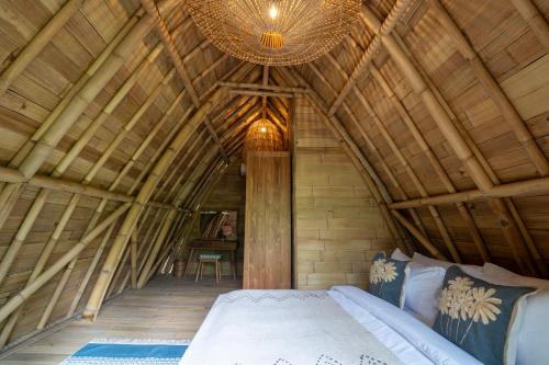 a bedroom with a large bed in a wooden ceiling at Mahajiva in Badung