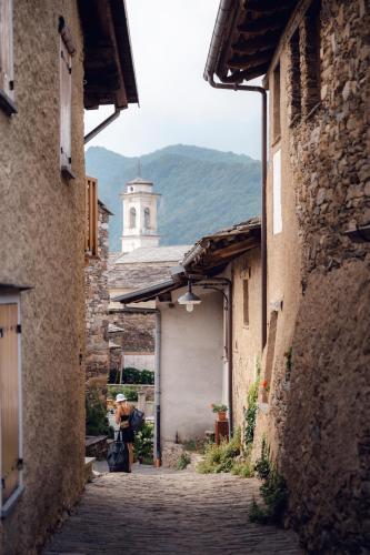 an alley with a building with a clock tower in the distance at Agriturismo LO PUY in San Damiano Macra