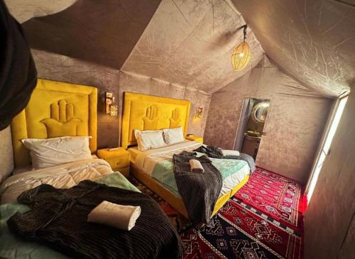a small room with two beds in a tent at Merzouga Lovely Luxury Camp in Merzouga