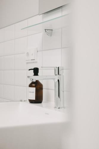 a bottle of soap sitting next to a bathroom sink at DOM Apartment I - modern & zentral mit kostenfreiem Parkplatz in Fulda