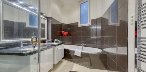 La salle de bains est pourvue d'un lavabo et d'une baignoire. dans l'établissement Renovated, Amazing & Huge Flat of 200 sqm Paris 16, à Paris