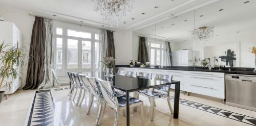 - une cuisine avec une table à manger et des chaises noires dans l'établissement Renovated, Amazing & Huge Flat of 200 sqm Paris 16, à Paris