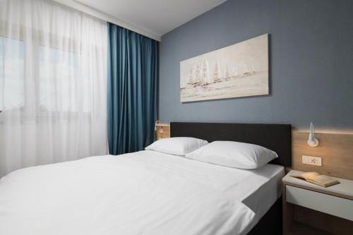 En eller flere senge i et værelse på Royal Rose Apartment