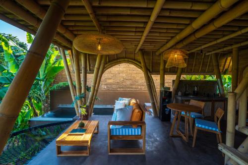 an outdoor living room with a table and chairs at Mahajiva in Badung
