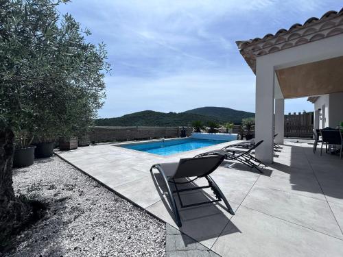 un patio avec des chaises et une piscine dans l'établissement Villa neuve 4 étoiles avec piscine et belles vues, à Sainte-Maxime