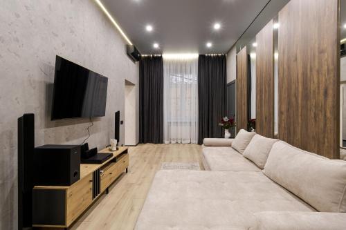 a living room with a couch and a flat screen tv at Royal jacuzzi apartment on Kostyushka 16 in Lviv