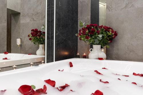 a bathroom with a white tub with red roses at Royal jacuzzi apartment on Kostyushka 16 in Lviv