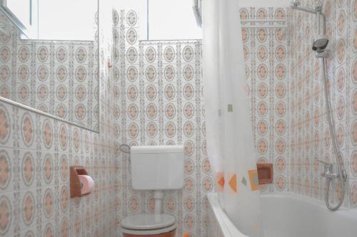 a bathroom with a toilet and a shower and a tub at Rosemary Apartment in Promajna