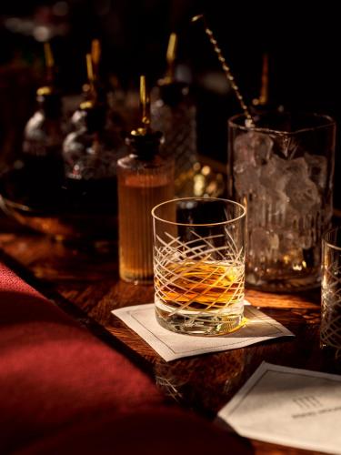 un verre de whisky assis sur une table dans l'établissement The Willows Palm Springs, à Palm Springs