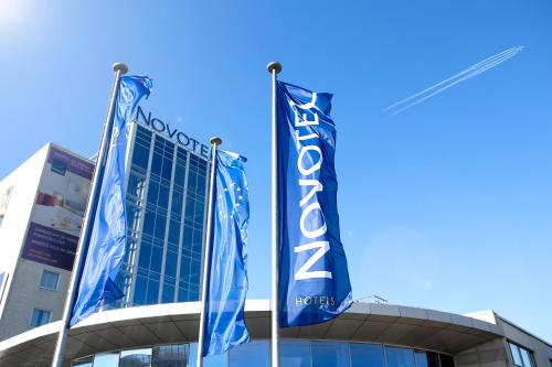 a building with blue flags in front of it at Novotel Warszawa Airport in Warsaw