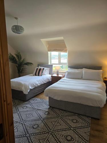 a bedroom with two beds and a window at Benroe House - 5 bedrooms in Killybegs