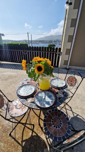 a table with plates and a vase of sunflowers on a patio at Benroe House - 5 bedrooms in Killybegs