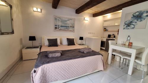 a bedroom with a large bed and a kitchen at SPQR Studios Valletta in Valletta