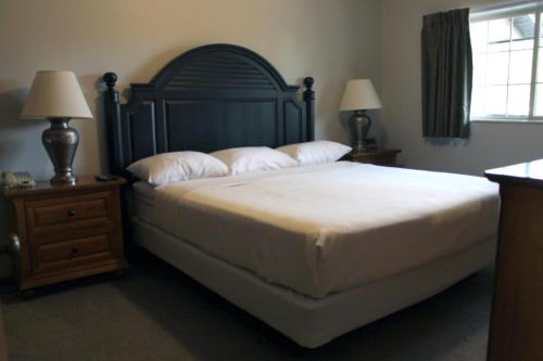 a bedroom with a large bed with pillows and two lamps at Wild Eagle Lodge, 2 bedroom 2nd floor condo, #216 in Eagle River