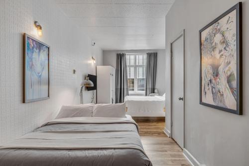 a white bedroom with a large bed in it at Initial 303 Québec in Quebec City