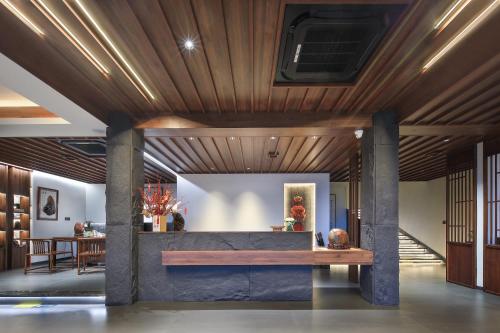 a living room with a wooden ceiling and a table at Longji Skyreach Peak Resort - Golden Buddha Summit in Longsheng