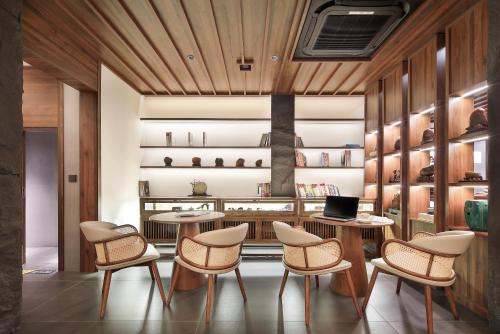 a room with two tables and chairs and shelves at Longji Skyreach Peak Resort - Golden Buddha Summit in Longsheng