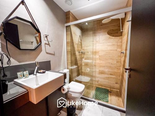 a bathroom with a toilet and a sink and a shower at Edifício Way Tambaú in Tambaú