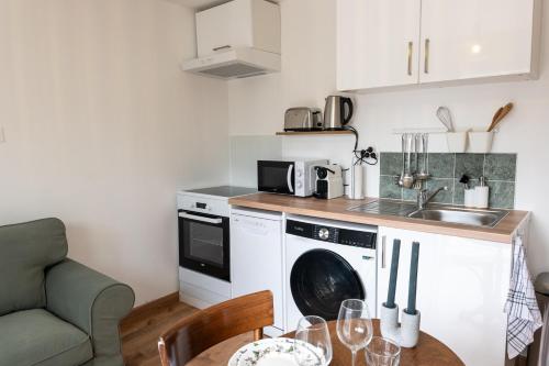 une cuisine avec une machine à laver et une table dans l'établissement La Tiny - Sleep in La Ciotat, à La Ciotat