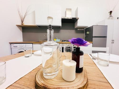 a bottle and a candle on a wooden table in a kitchen at CASA VERDi 37 CAMERA AMETISTA in Porto SantʼElpidio