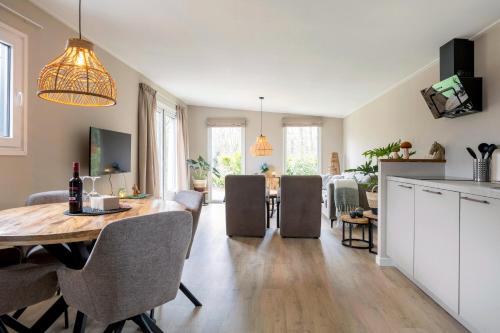 a kitchen and living room with a table and chairs at De Bospaddenstoel 4-19 in Putten