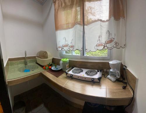 a kitchen with a counter with a stove and a window at Hostal La India in Valle de Anton