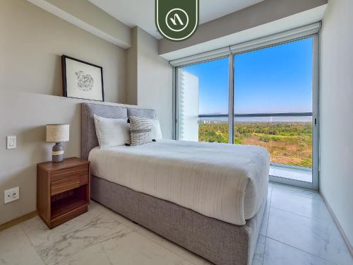 a bedroom with a large bed and a large window at Luxury 3 BR Condo - Beach Access 1 Block Away in Bucerías