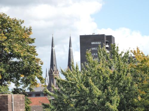 a group of buildings in a city with trees at Hostel Roots in Tilburg