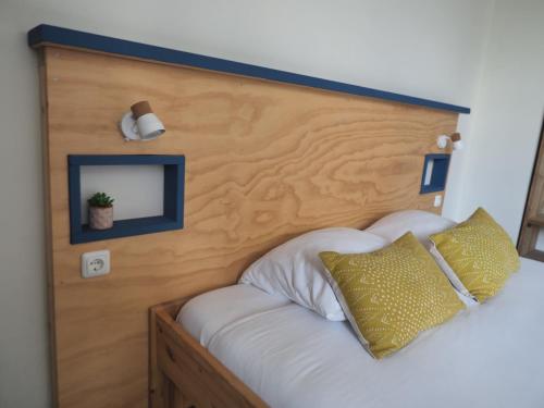 a bed with a wooden head board with a mirror at Hostel Roots in Tilburg