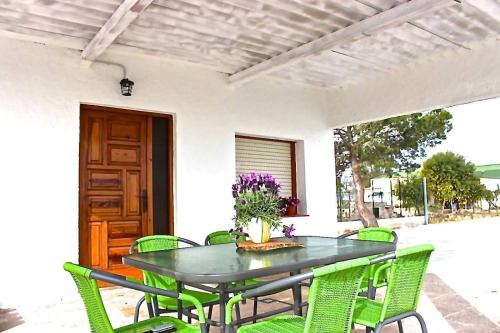 een zwarte tafel met groene stoelen op een terras bij Casa Bassa de La Marquesa in Deltebre