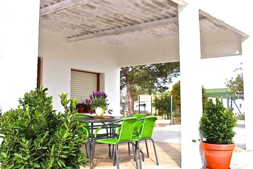 een terras met een tafel, stoelen en planten bij Casa Bassa de La Marquesa in Deltebre